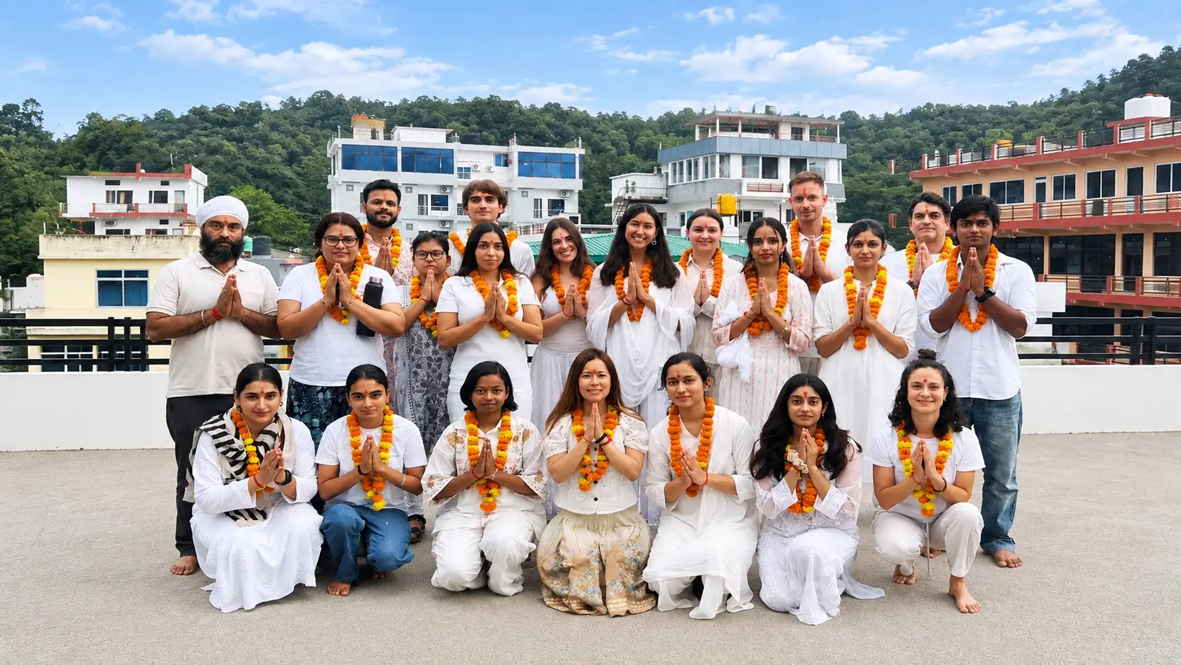 Yoga teacher training students in Namaste with marigold garlands at Rishikul Yogshala Rishikesh